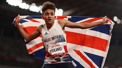 Thomas Young holding a Union Jack flag at the Paralympics