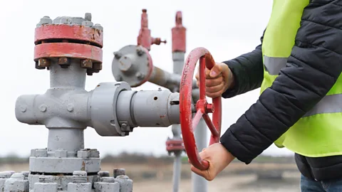 Getty Images An engineer turns the vent of a gas pump (Credit: Getty Images)