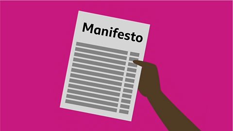 A hand holding a piece of paper with the word manifesto.