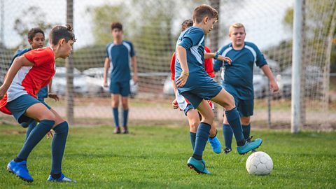 Group of teenagers playing in a football match