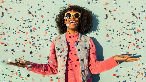 Smiling woman being showered with confetti