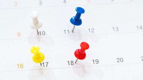 Close-up of pins marking dates in a calendar