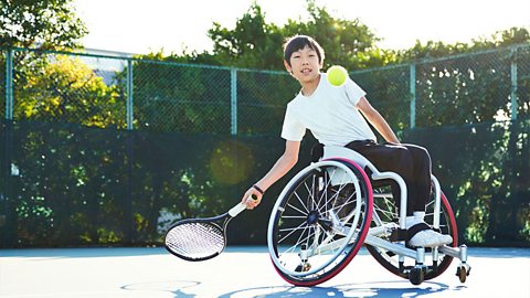 Boy in a wheelchair playing tennis