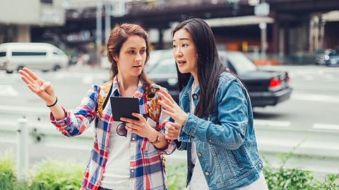 A woman passing on directions to another woman.