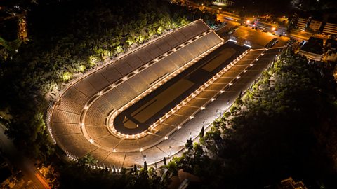 Aerial view of the Panathenaic Stadium lit up at night 