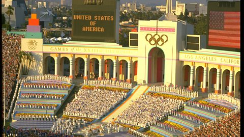 A crowd of people and a marching band in the Coliseum Stadium