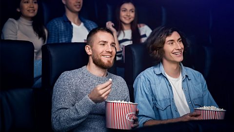A group of friends eating popcorn at the cinema