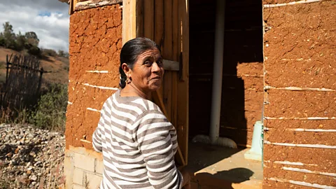 Stephania Corpi Arnaud Agustina Ortiz, stands beside her 20,000-litre ferrocement tank at her home in the community of Xixovo, Oaxaca, on 5 December 2023 (Credit: Stephania Corpi Arnaud)