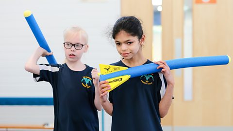 Two children holding foam javelins