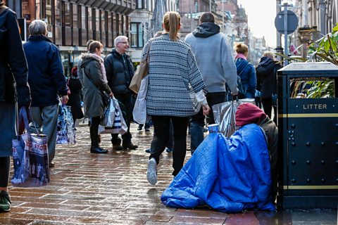 Homeless person sitting on the pavement in Glasgow.