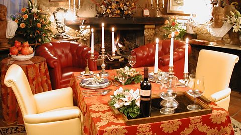 Two chairs at a table. The table is decorated with flowers and candles.