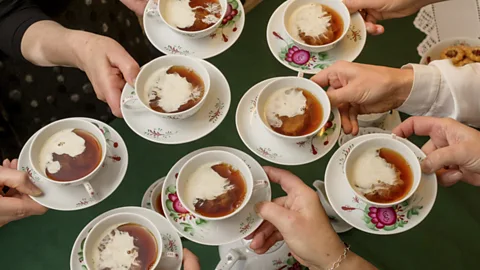 Bünting Tea Museum People holding traditional cups and saucers of East Frisian tea (Credit: Bünting Tea Museum)