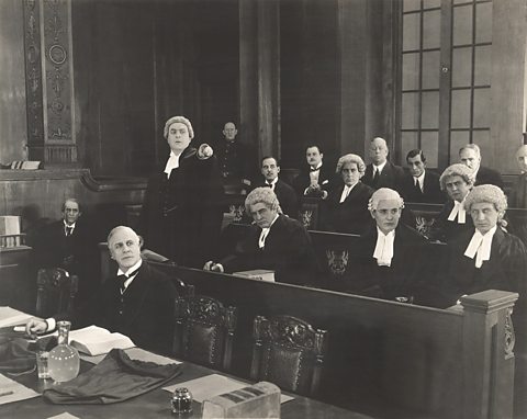 Photo of old courtroom with barristers wearing wigs, a tradition dating back to the reign of Charles II