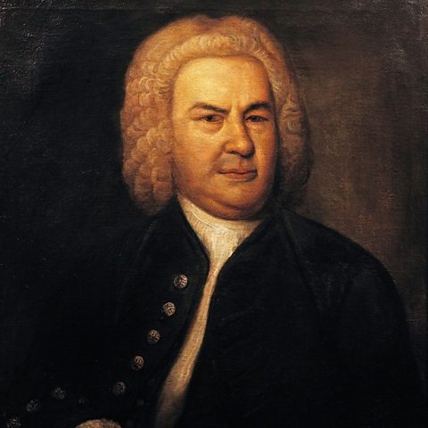 An oil portrait painting of Johann Sebastian Bach. He is wearing a white curly wig and a ruffled white shirt with a jacket with buttons down the left side.