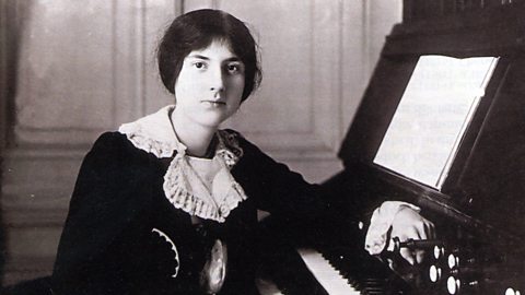 Black and white photograph of French composer, Lili Boulanger, sitting at a keyboard.