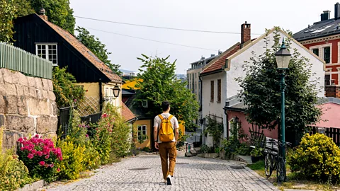 Getty Images Rear view of a man with backpack walking in Oslo old town (Credit: Getty Images)