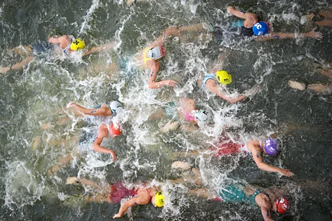 Natalie Van Coevorden, da AP Austrália, no centro, compete na etapa de natação da competição individual feminina de triatlo nas Olimpíadas de Verão de Paris em 2024 (Crédito: AP)