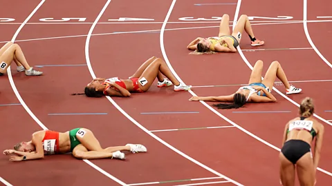 Getty Images Athletes lie on the track after a race (Credit: Getty Images)