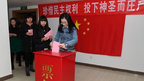 Neach-bhòtaidh ann an ionad-bhòtaidh ann am Beijing, 2016