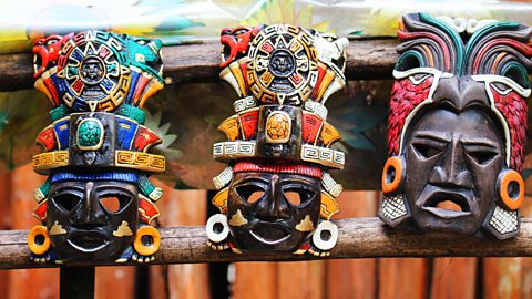 Image of three colourful Mayan masks. 