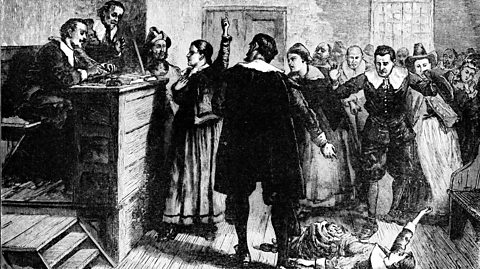 A courtroom scene featuring a crowd at the trial of a witch in Salem