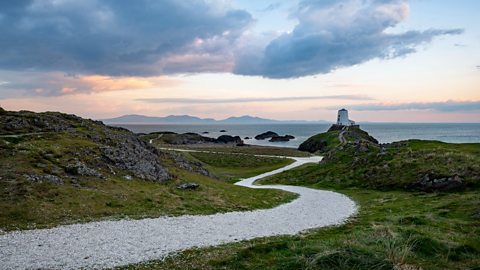 The coast of Anglesey in Wales with a lighthouse in the distance