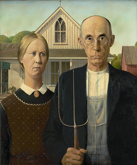 A woman stands next to a man with a pitchfork