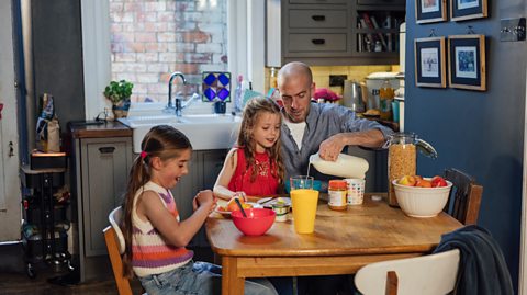 A dad and his two girls eating breakfast together