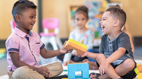 Nursery age kids playing together using blocks