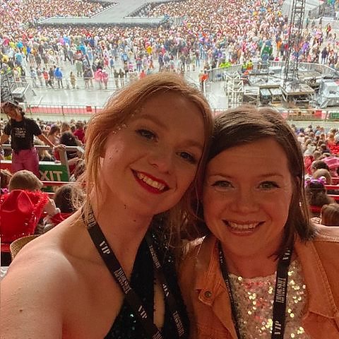 A photo of two women at a Taylor Swift concert, one with long ginger hair and the other with a brown bob