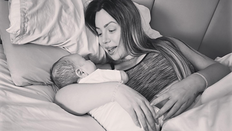 Holly Hagan-Blyth cradling her son Alpha-Jax in bed.