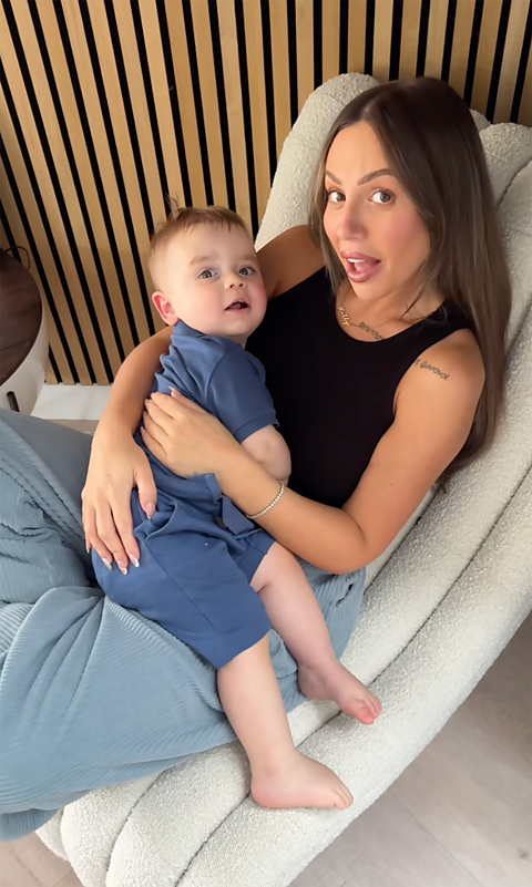 Holly and Alpha-Jax sit on a chair in the hallway of their home.