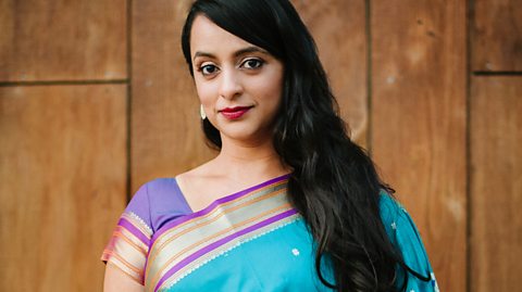 Composer Reena Email smiling at camera, wearing a turquoise and pink sari