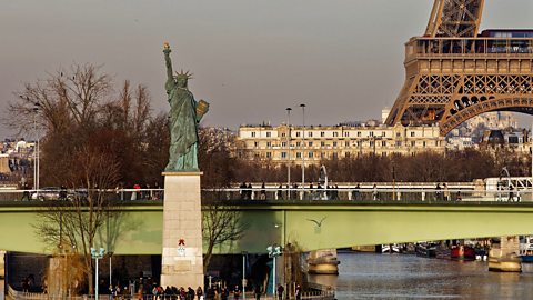 The Paris version of the Statue of Liberty standing in front of the Eiffel Tower