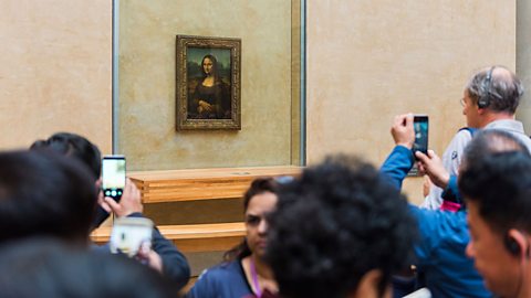 People viewing the Mona Lisa within the Louvre art gallery