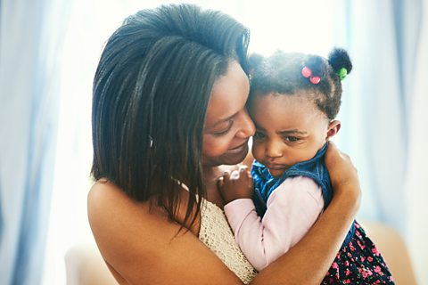 A mum hugging her concerned looking daughter.