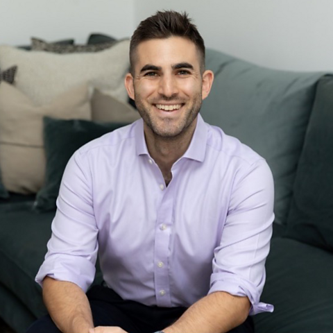 Clinical psychologist Dr Matt Slavin sits on a sofa smiling at the camera