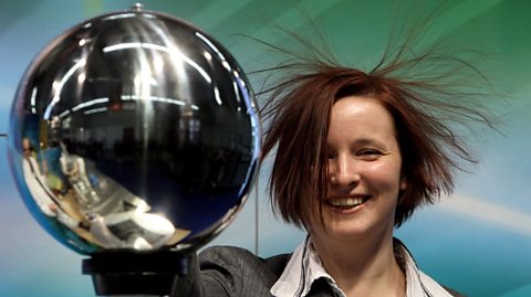 A woman's hair stands up as she touches an Van de Graaff generator during the International Toy Fair on February 4, 2010 in Nuremberg, Germany