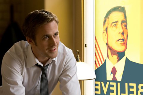 Ryan Gosling in the foreground with a poster of George Clooney as president towards the side