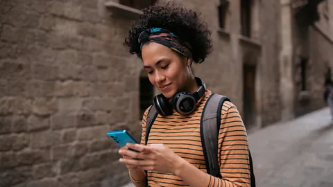 Getty Images Travellers are often tethered to their phones as they navigate a new place (Credit: Getty Images)