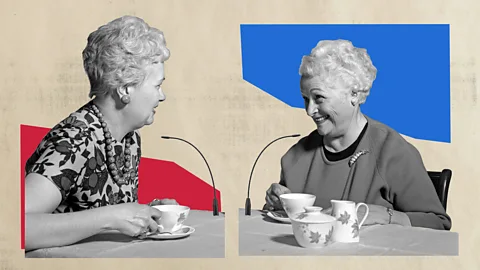 Javier Hirschfeld/Getty Images Two elderly women talk and drink tea (Credit: Javier Hirschfeld/Getty Images)