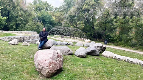 Steve Lyons Niigaan Sinclair duduk di atas batu di antara bebatuan lain di lapangan (Kredit: Steve Lyons)