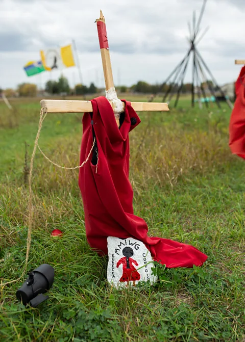 Hak atas foto Getty Images Gaun merah yang tergantung di halaman dan Proyek REDress Jaime Black di Museum Hak Asasi Manusia Kanada merupakan pengingat kuat akan gerakan MMIWG2S+.