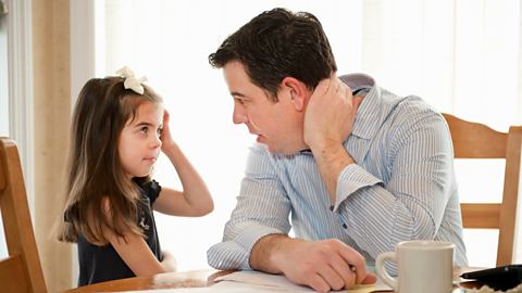 A dad talks frankly to his young daughter at the dining table.