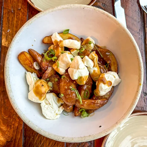 Suzanne Podhaizer The trail allows cyclists to sample Québec's unique flavours, like dressed up poutine (Credit: Suzanne Podhaizer)