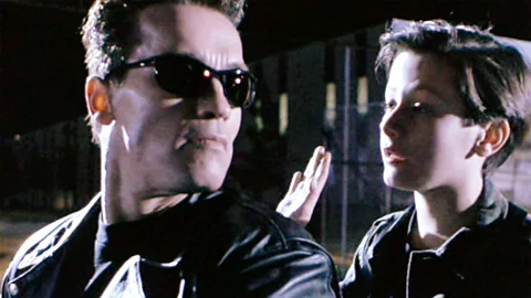 Getty Images In the 1991 sequel, Terminator 2: Judgment Day, the T-800 (Arnold Schwarzenegger)  protects John Connor (Edward Furlong) (Credit: Getty Images)