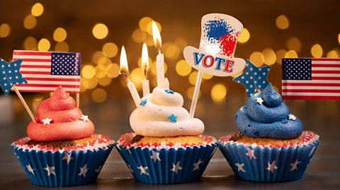 Three decorated cupcakes, one with red icing, one with white icing, one with blue icing