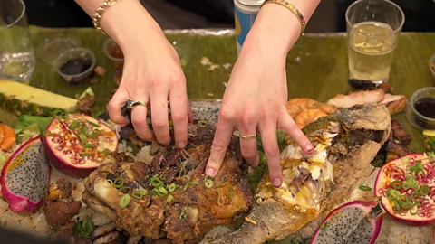 Darryl Laiu/ BBC At Tradisyon, kamayan feasts typically include crispy pata (fried pork knuckles), garlic chilli prawns and fried fish (Credit: Darryl Laiu/ BBC)