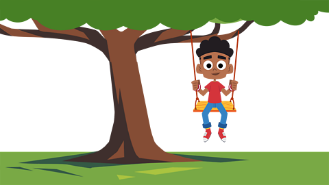 A young child sat on a rope swing attached to an oak tree