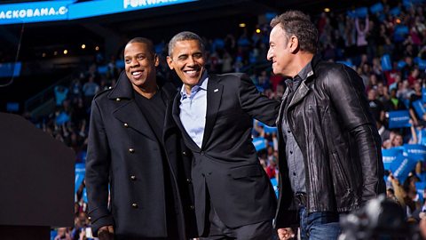 Obama embraces Jay-Z and Bruce Springsteen in front of a crowd